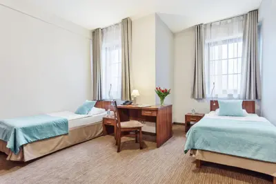 Łóżko lub łóżka w pokoju w obiekcie Hotel Modrzewiowy Dwór