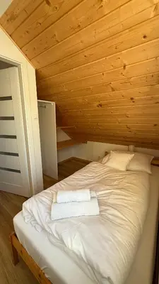Łóżko lub łóżka w pokoju w obiekcie Domki Wilcza B