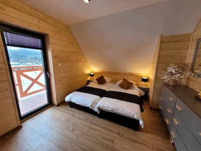 Łóżko lub łóżka w pokoju w obiekcie Osada Orlica klimatyczne domki z widokiem na góry i termalnym SPA sauna jacuzzi 4 km od Zieleniec Ski Arena