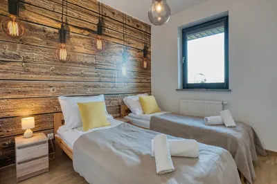 Łóżko lub łóżka w pokoju w obiekcie Wakacyjne Historie - nowoczesne i komfortowe apartamenty ze SPA u podnóża Śnieżnika