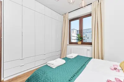 Łóżko lub łóżka w pokoju w obiekcie Nowa Tęczowa Apartments Promenada Staromiejska by Noclegi Renters