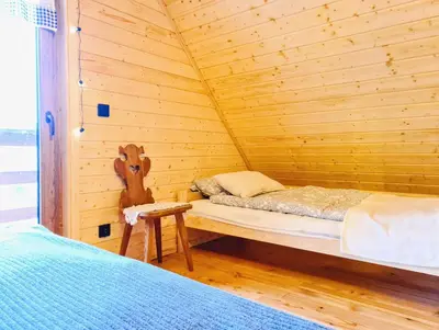 Łóżko lub łóżka w pokoju w obiekcie Osada Sierpnica - Uroczy dom z kominkiem i balią w Górach Sowich