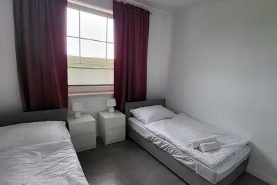 Łóżko lub łóżka w pokoju w obiekcie Apartamenty Czerwona Stodoła